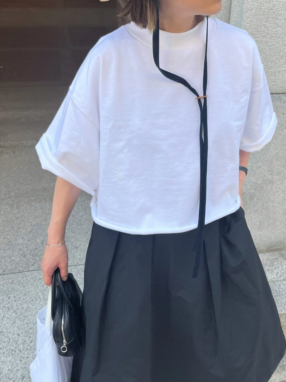 ホワイト系のTシャツ/カットソー、ブラック系のハット、シルバー系のブレスレットを着用したレディースの夏コーディネートの4枚目の写真