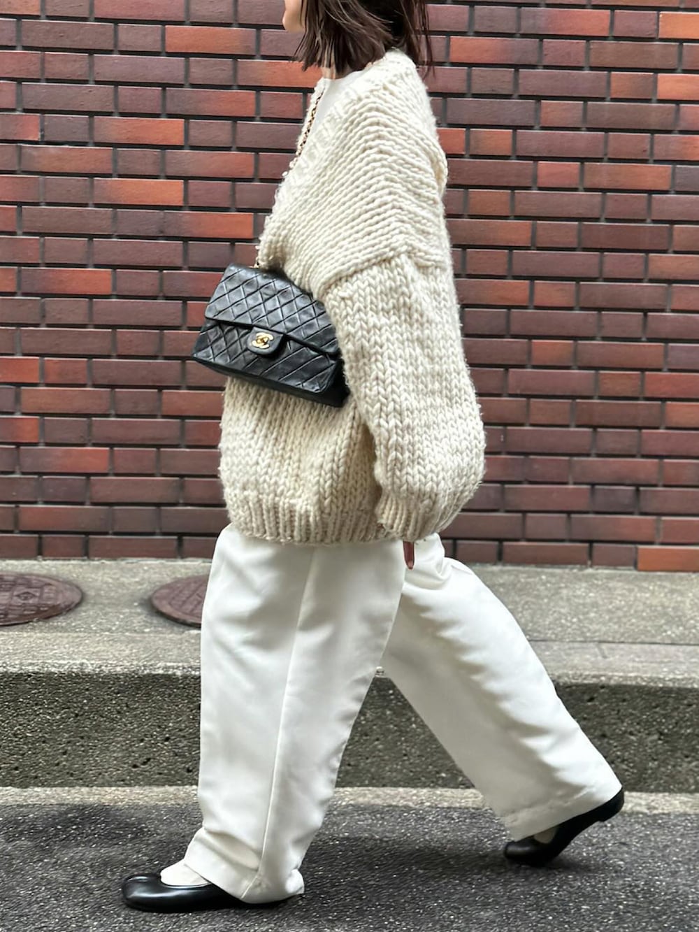 ホワイト系のパンツ、ブラック系のバレエシューズ、シルバー系のリングを着用したレディースの冬コーディネートの2枚目の写真