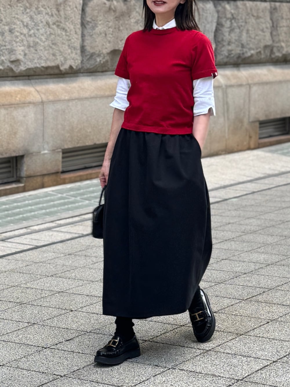 レッド系のニット/セーター、ブラック系のスカートを着用したレディースの冬コーディネートの5枚目の写真
