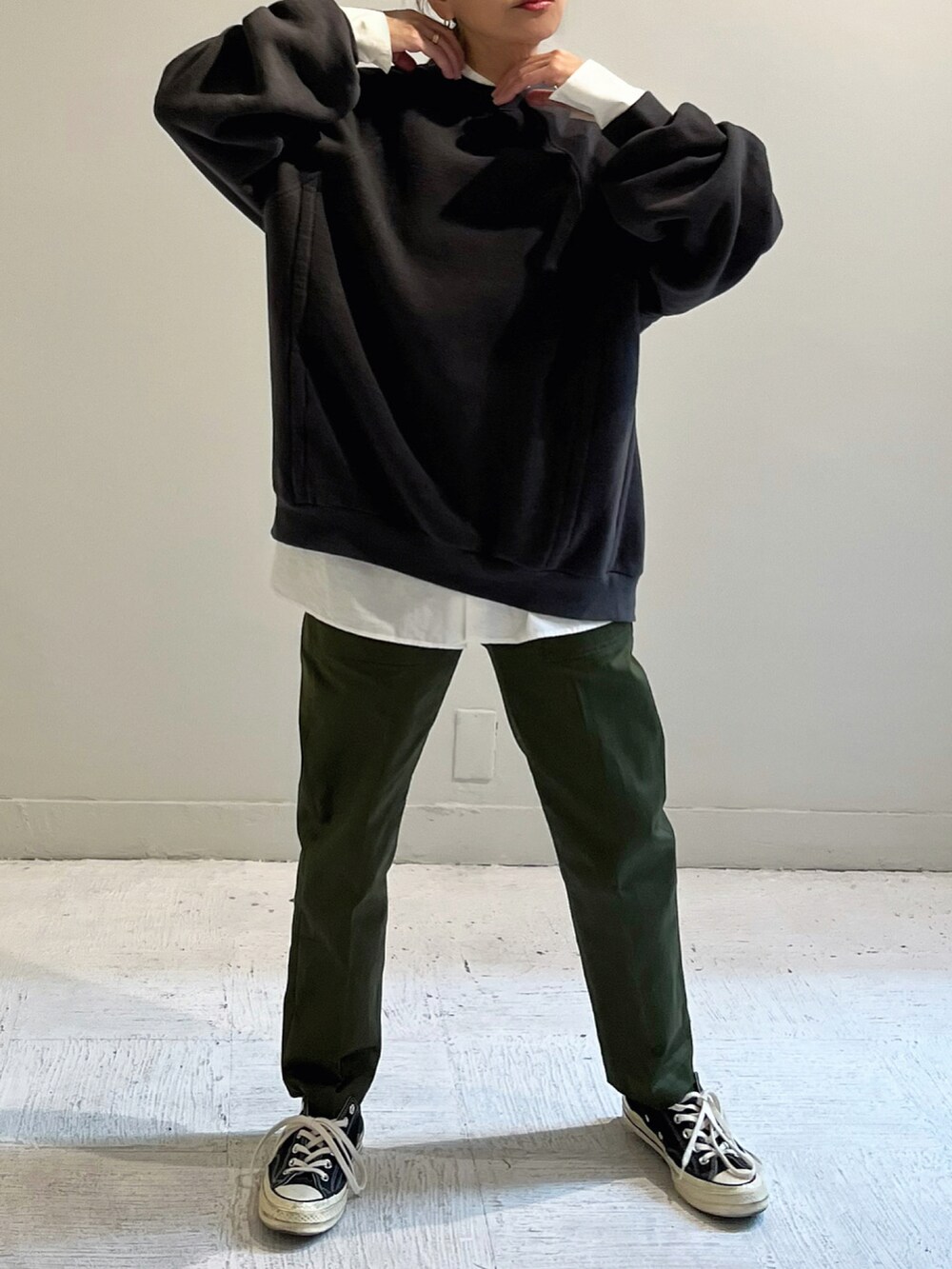 ブラック系のスウェット、グリーン系のパンツ、シルバー系のピアス（両耳用）を着用したレディースの秋コーディネートの3枚目の写真