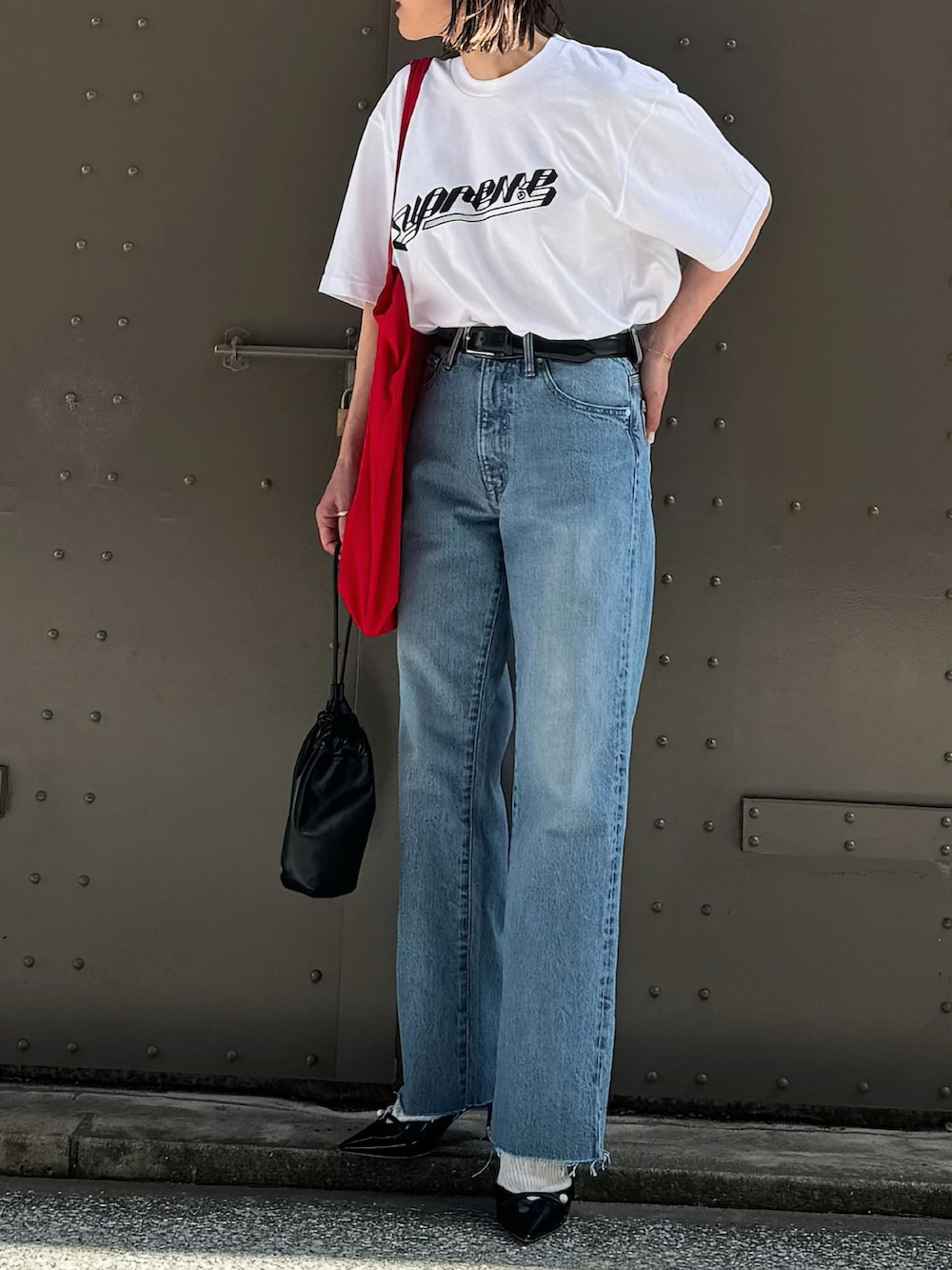 ブルー系のデニムパンツ、ブラック系のパンプス、シルバー系のブレスレットを着用したレディースの春コーディネートの3枚目の写真