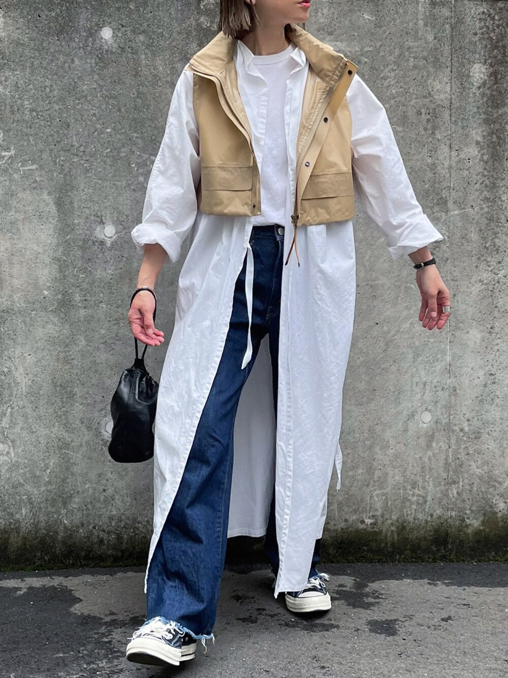 ブルー系のデニムパンツ、シルバー系のブレスレットを着用したレディースの春コーディネートの2枚目の写真