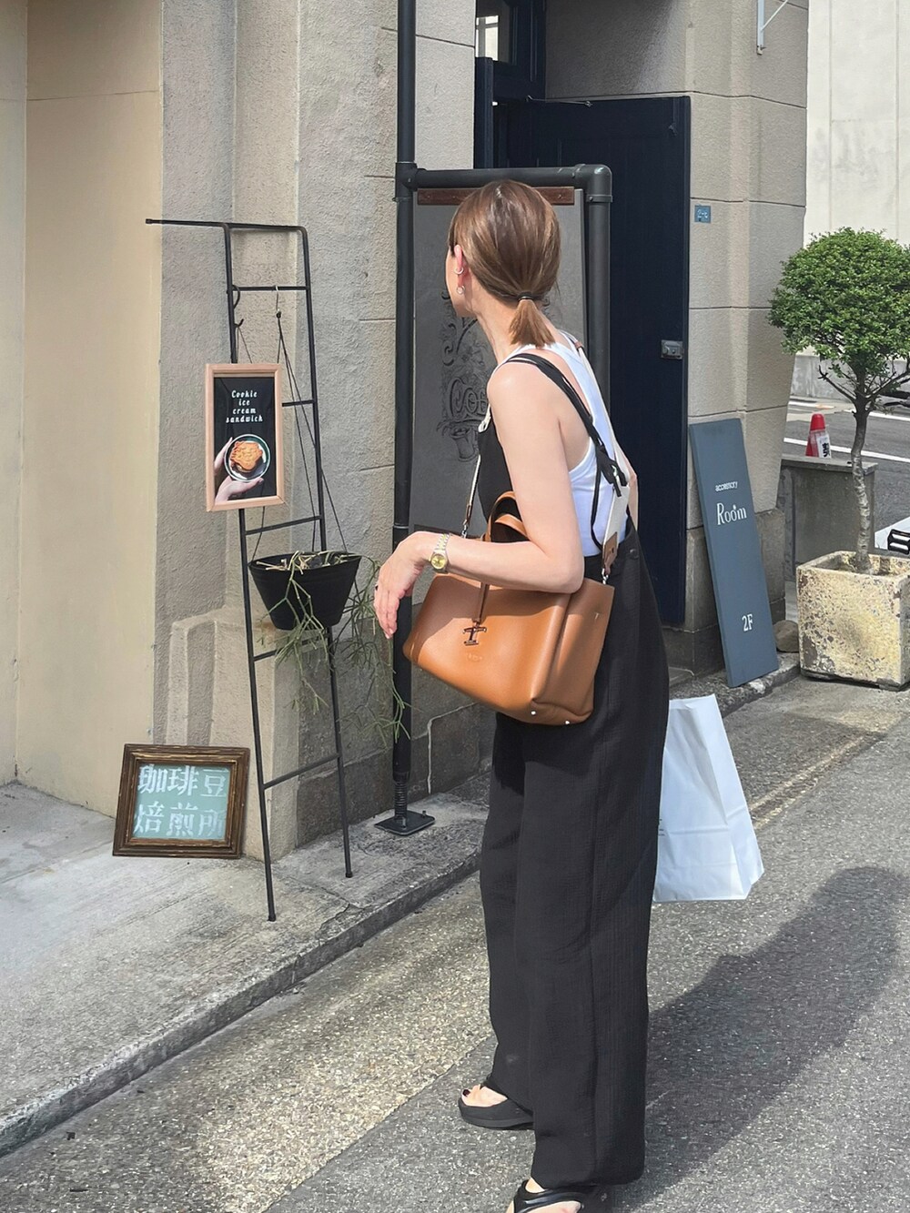 ホワイト系のタンクトップ、ブラック系のサロペット/オーバーオール、ブラック系のサンダルを着用したレディースの秋コーディネートの2枚目の写真