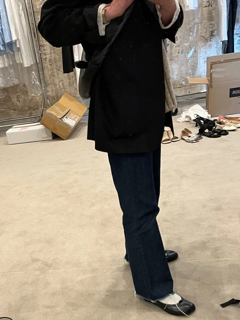 ブラック系のテーラードジャケット、ブラック系のバレエシューズ、ブラック系のショルダーバッグを着用したレディースの春コーディネートの2枚目の写真