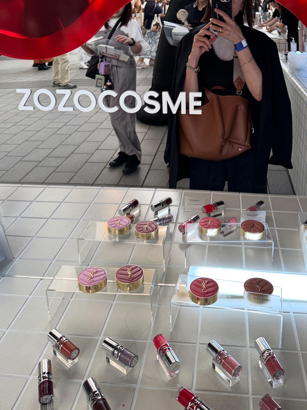 ブルー系のデニムパンツ、ホワイト系のタンクトップ、ブラック系のスニーカーを着用したレディースの秋コーディネートの4枚目の写真