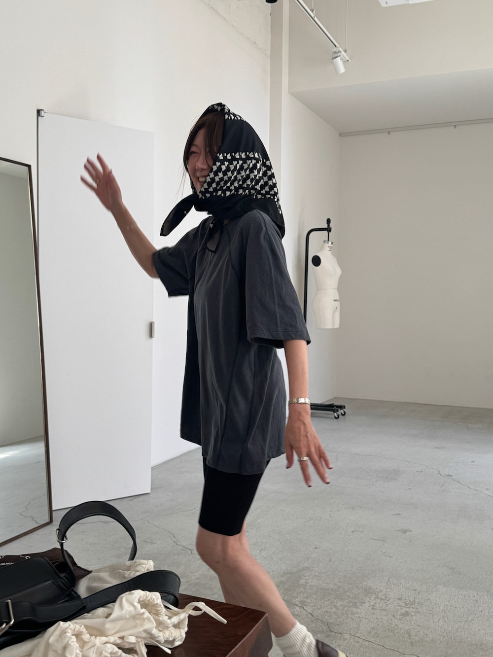 ブルー系のTシャツ/カットソー、ホワイト系のスニーカー、ブラック系のストール/ショールを着用したレディースの秋コーディネートの3枚目の写真