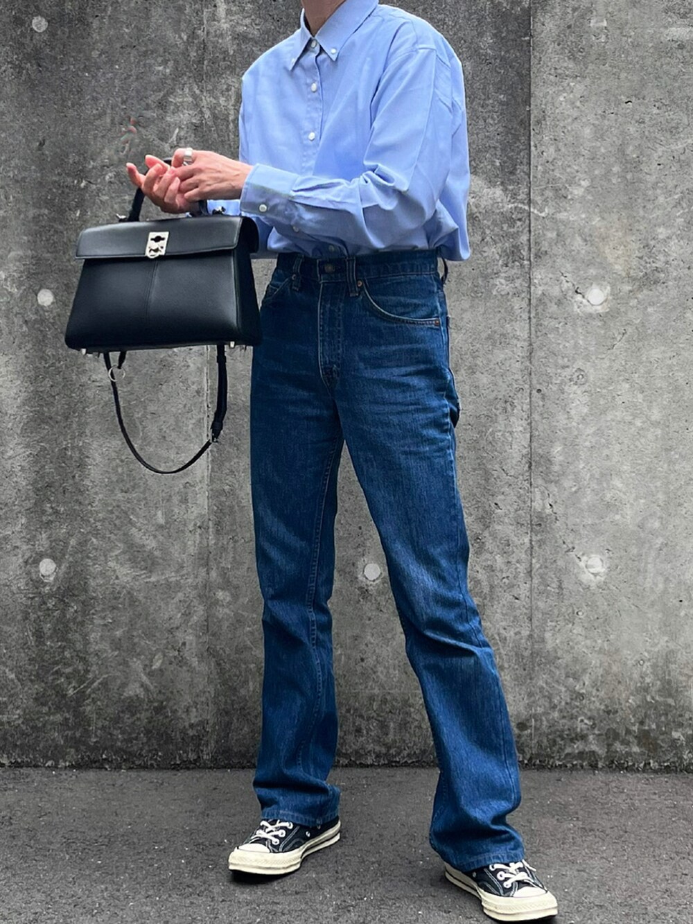 ブルー系のシャツ/ブラウス、ブラック系のハンドバッグを着用したレディースの春コーディネートの2枚目の写真