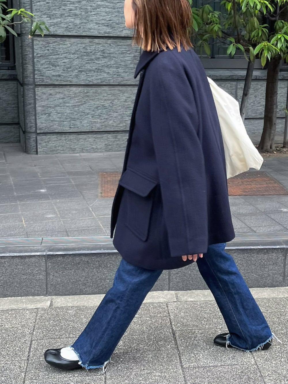 ブラック系のバレエシューズ、ブルー系のピーコート、シルバー系のピアス（両耳用）を着用したレディースの秋コーディネートの2枚目の写真