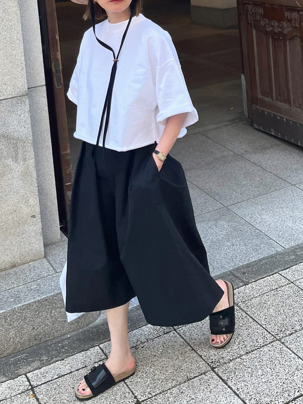 ホワイト系のTシャツ/カットソー、ブラック系のハット、シルバー系のブレスレットを着用したレディースの夏コーディネートの3枚目の写真