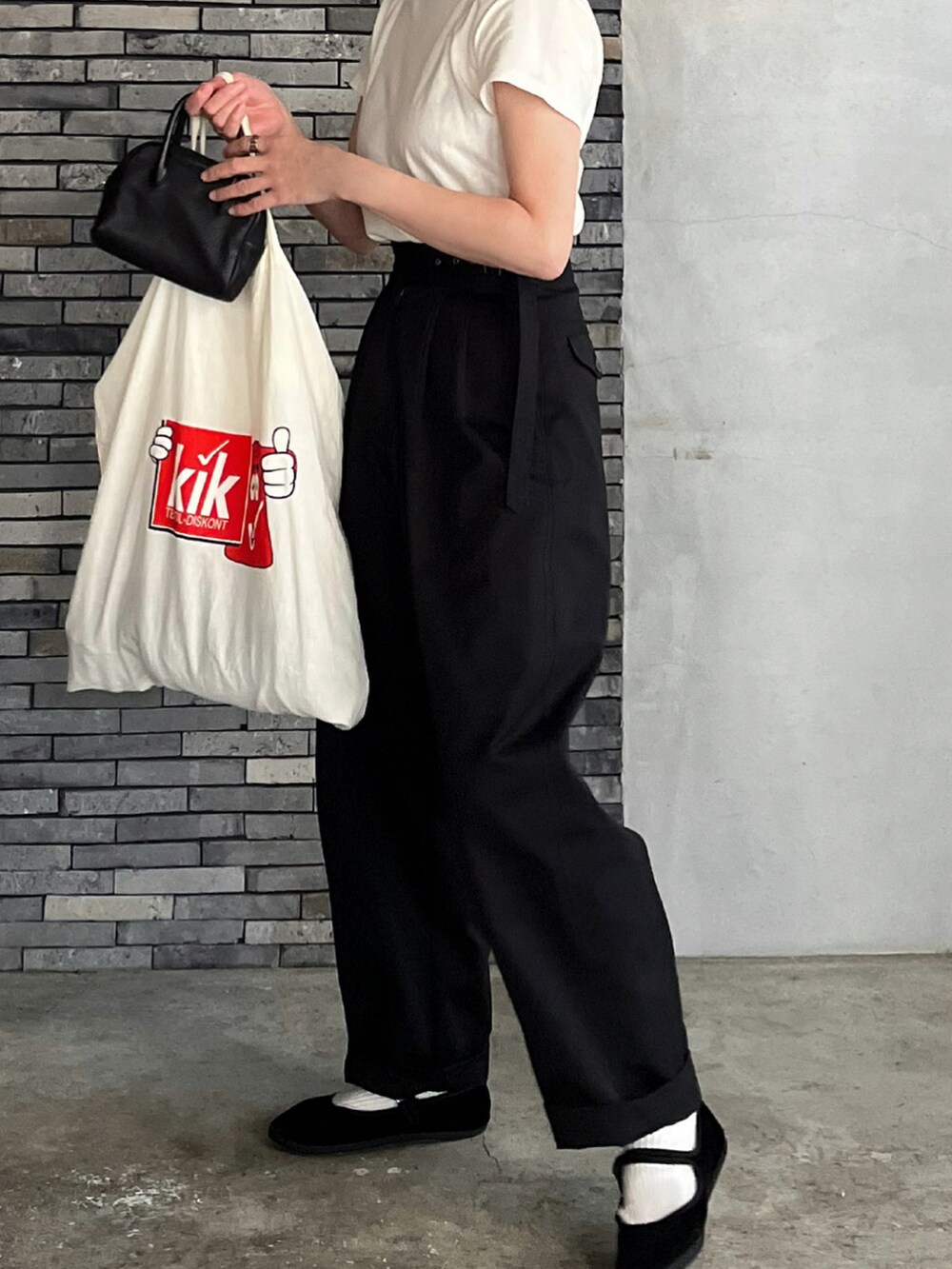 ブラック系のチノパンツ、ブラック系のその他シューズ、ブラック系のボストンバッグを着用したレディースの冬コーディネートの3枚目の写真