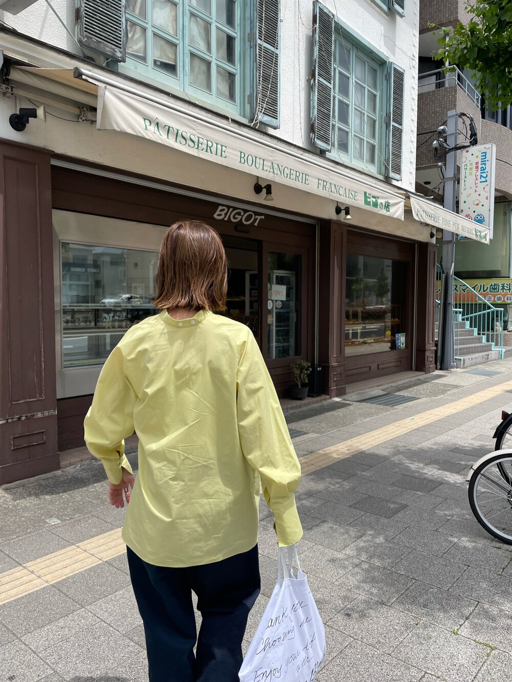 イエロー系のシャツ/ブラウス、ベージュ系のサンダルを着用したレディースの夏コーディネートの2枚目の写真