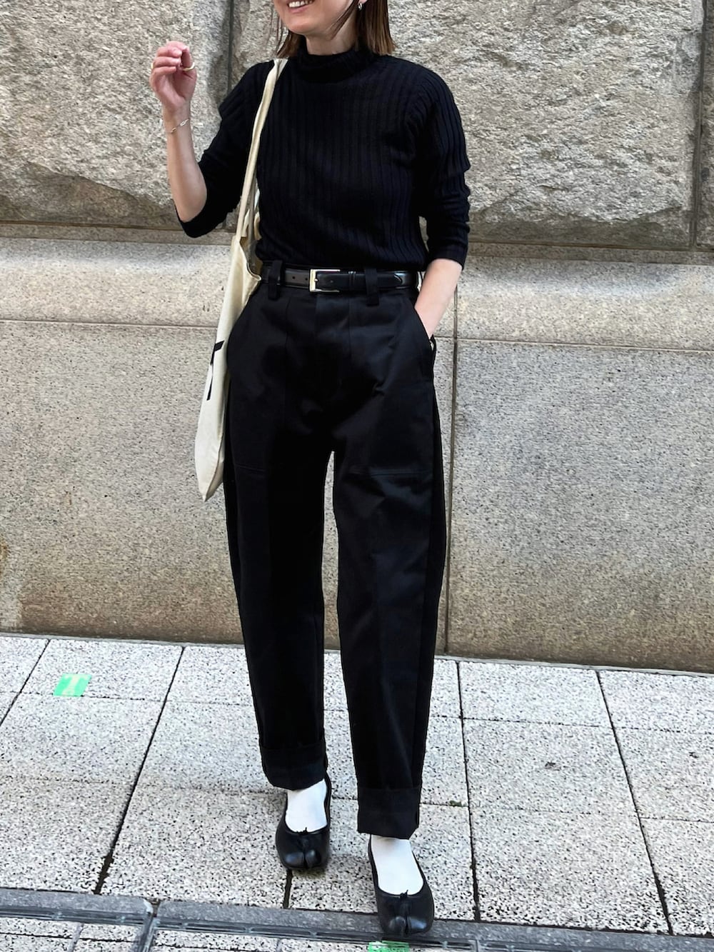 ブラック系のパンツ、ブラック系のバレエシューズ、ブラック系のベルトを着用したレディースの秋コーディネートの2枚目の写真