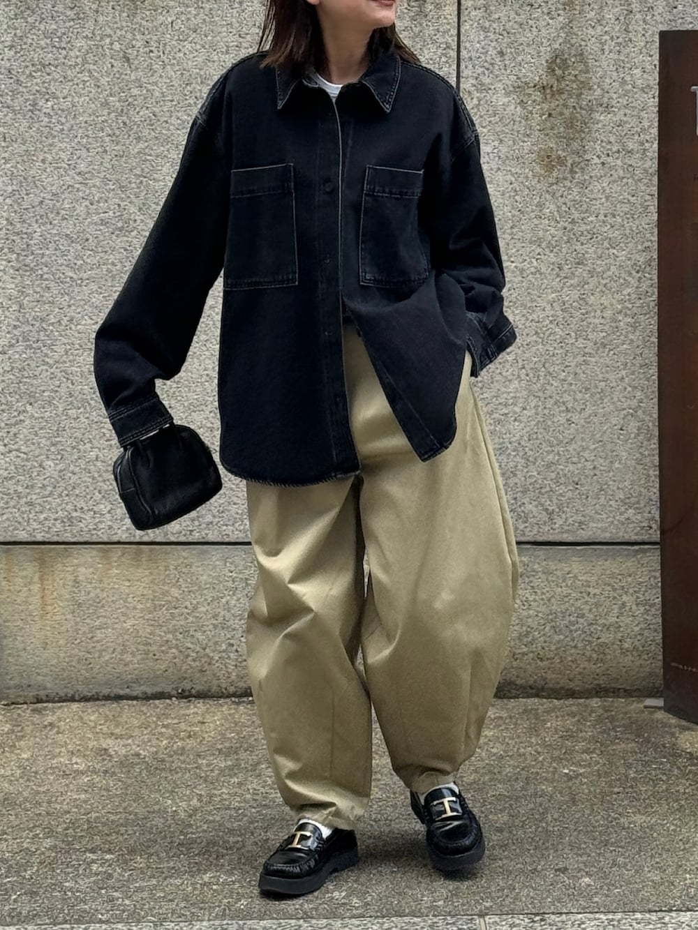 ベージュ系のチノパンツ、ブラック系のローファー、ブラック系のボストンバッグを着用したレディースの冬コーディネートの2枚目の写真