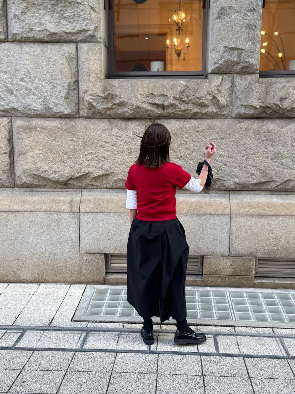 レッド系のニット/セーター、ブラック系のスカートを着用したレディースの冬コーディネートの4枚目の写真