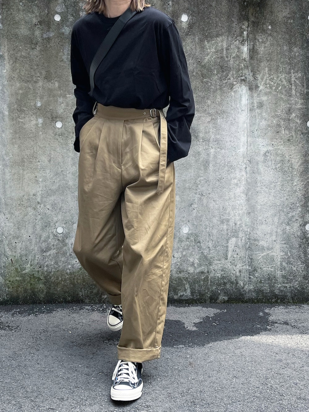 ブラック系のTシャツ/カットソー、ベージュ系のチノパンツ、ブラック系のボディバッグ/ウエストポーチを着用したレディースの春コーディネートの3枚目の写真