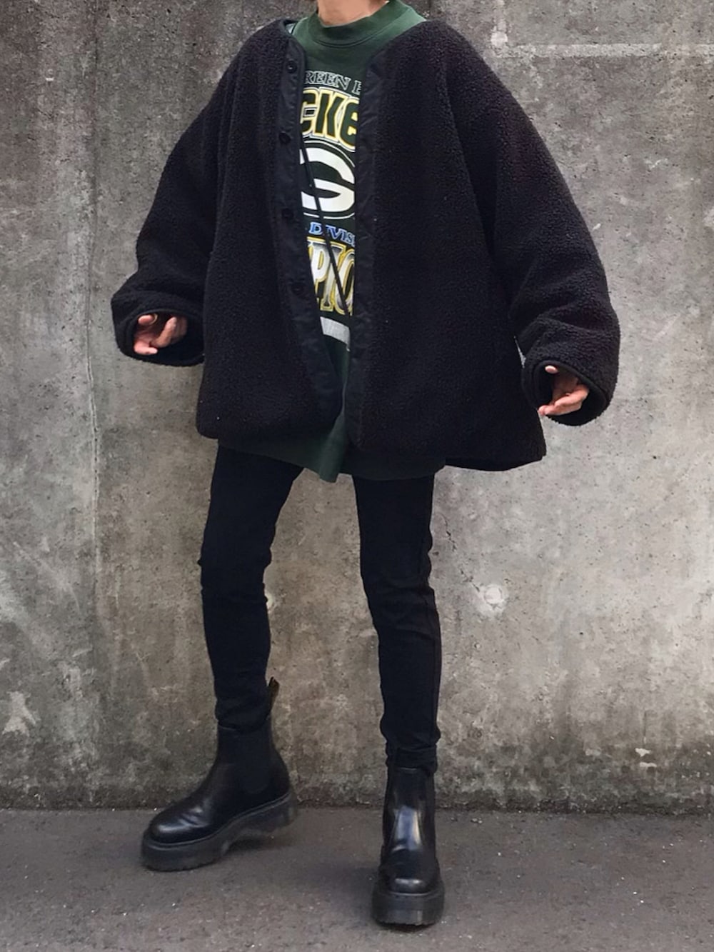 ブラック系のブーツ、ブラック系のその他アウターを着用したレディースの冬コーディネートの2枚目の写真