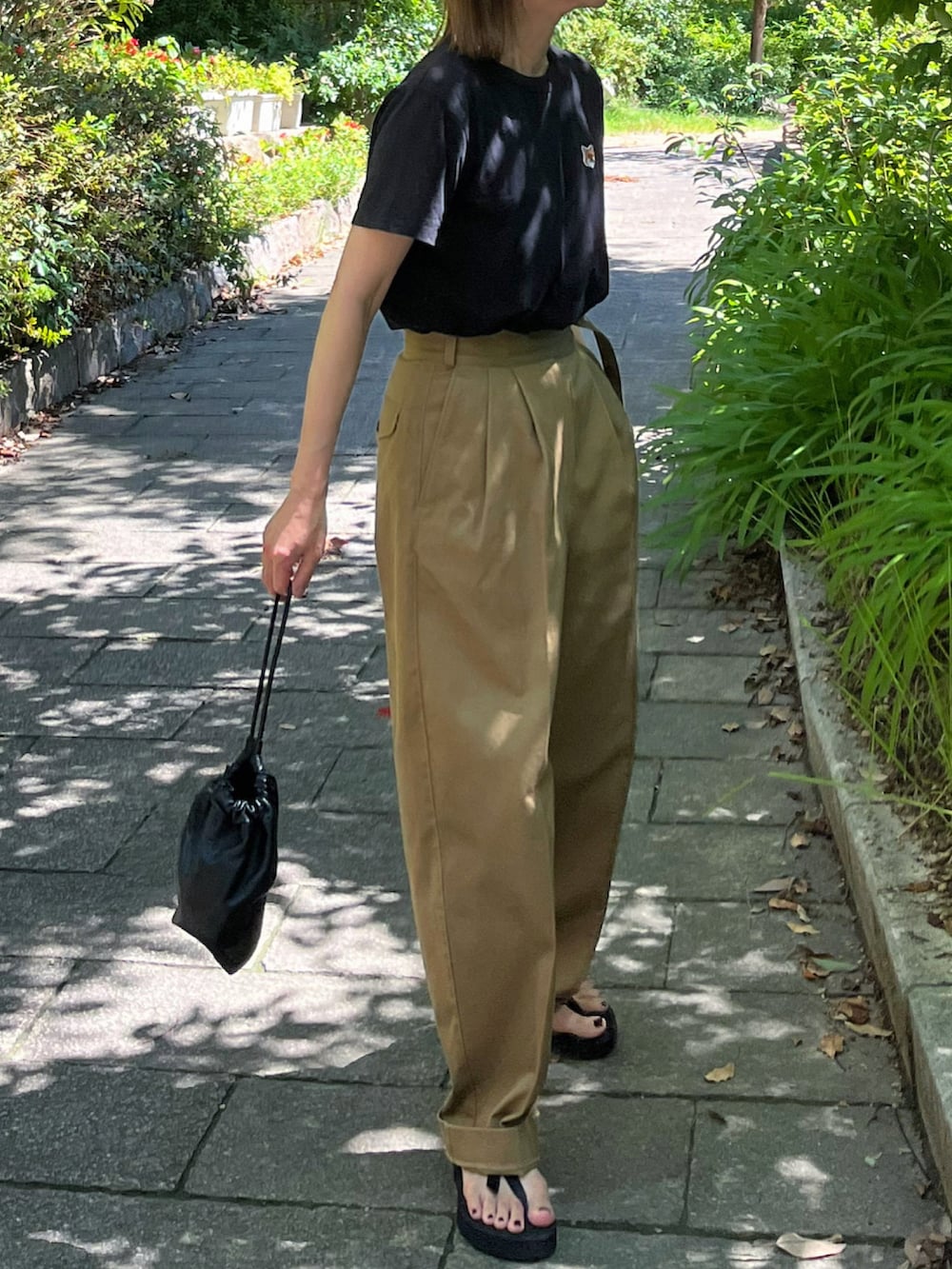 ブラック系のTシャツ/カットソー、ベージュ系のチノパンツを着用したレディースの夏コーディネートの3枚目の写真