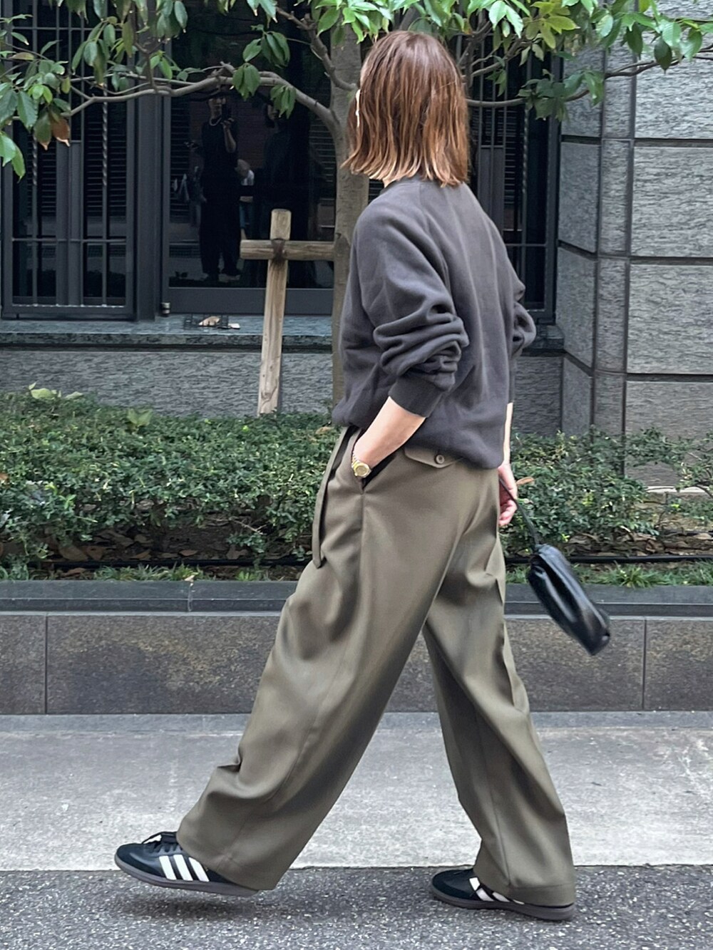 ブラック系のスウェット、グリーン系のパンツ、ブラック系のスニーカーを着用したレディースの夏コーディネートの5枚目の写真