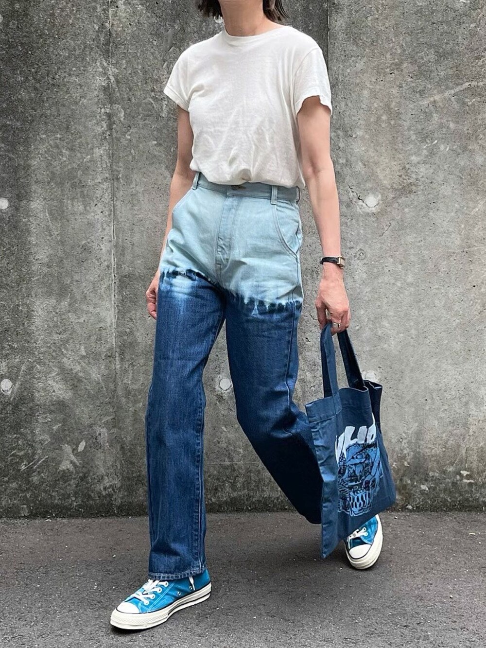 ブルー系のデニムパンツ、ブルー系のトートバッグを着用したレディースの春コーディネートの2枚目の写真