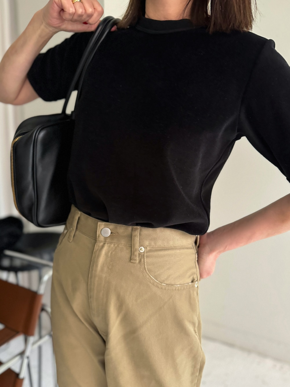 ブラック系のTシャツ/カットソー、ベージュ系のチノパンツを着用したレディースの春コーディネートの3枚目の写真