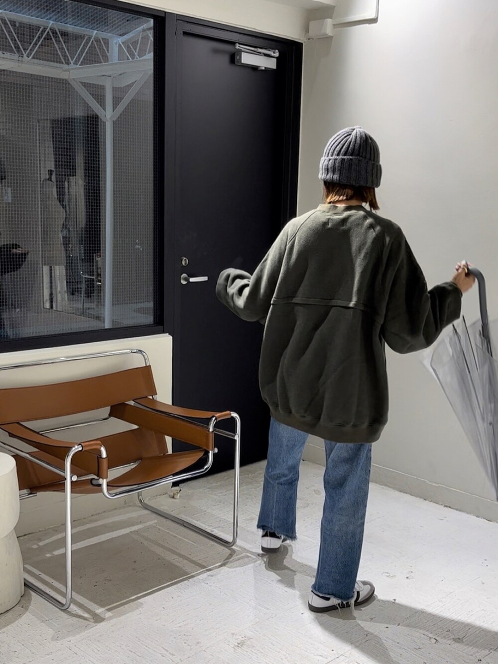 ブラック系のスウェット、ホワイト系のスニーカー、グレー系のニットキャップ/ビーニーを着用したレディースの秋コーディネートの4枚目の写真