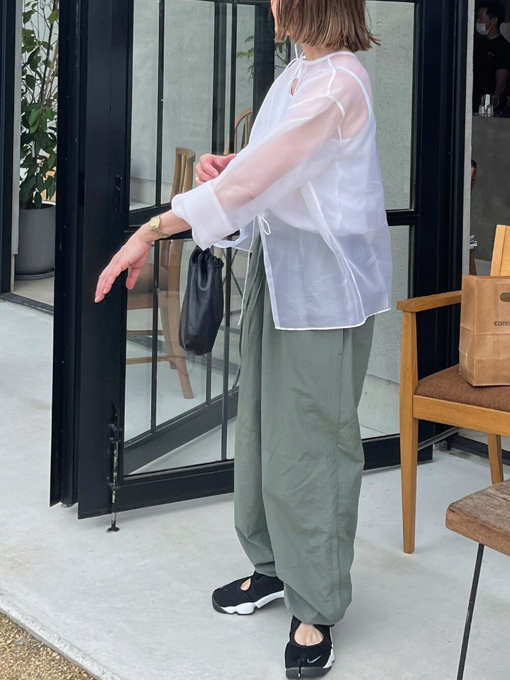 ホワイト系のシャツ/ブラウス、ブラック系のスニーカーを着用したレディースの夏コーディネートの3枚目の写真