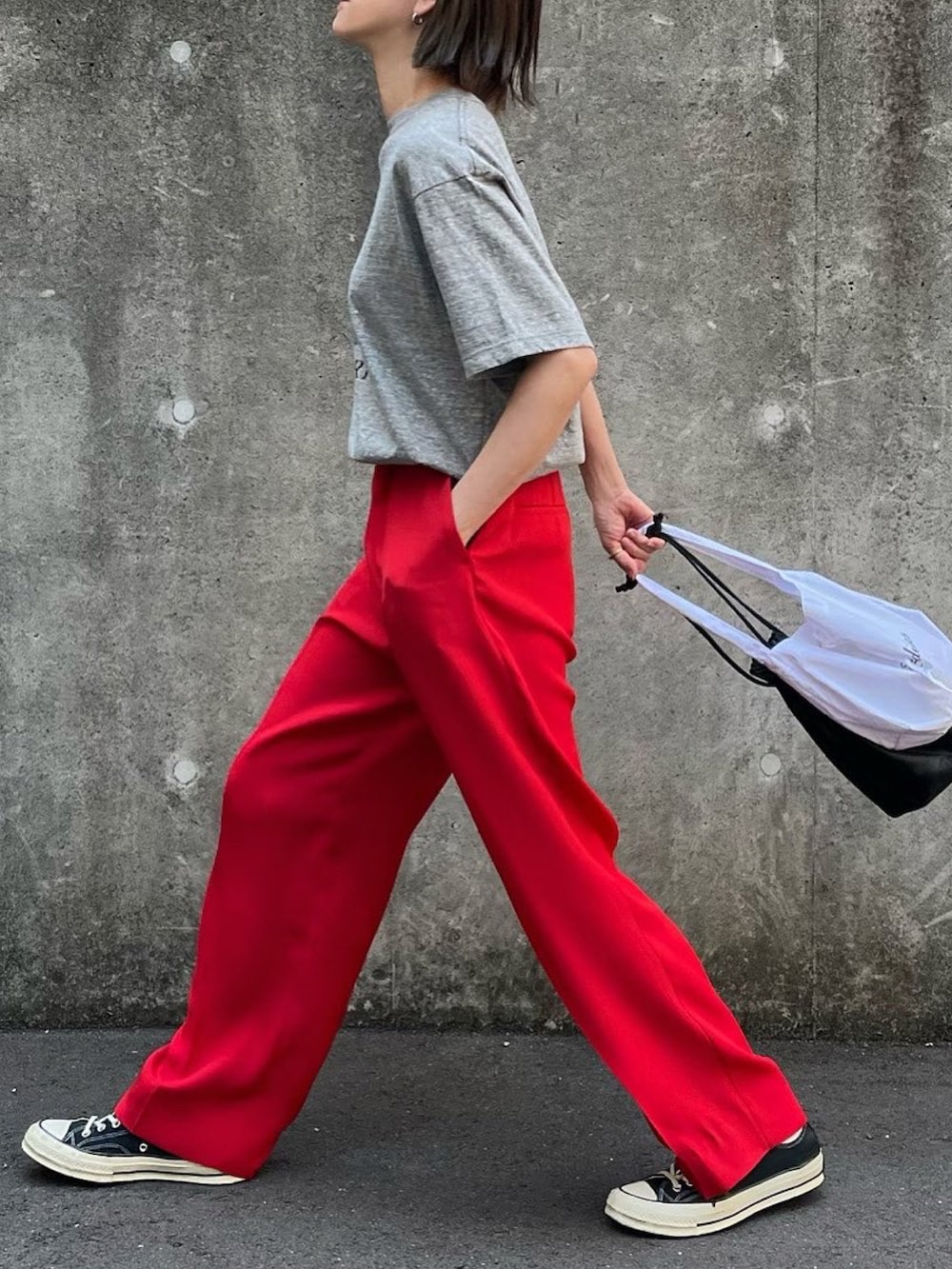 グレー系のTシャツ/カットソー、レッド系のその他パンツ、ブラック系のスニーカーを着用したレディースの春コーディネートの2枚目の写真