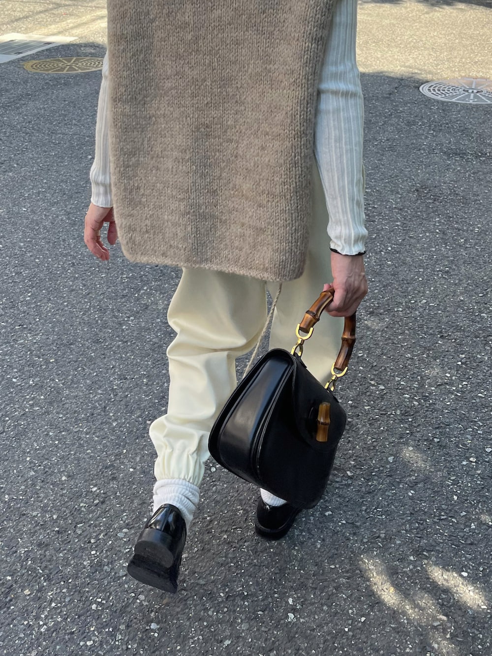 ホワイト系のパンツ、ブラック系のローファー、ブラウン系のストール/ショールを着用したレディースの秋コーディネートの2枚目の写真