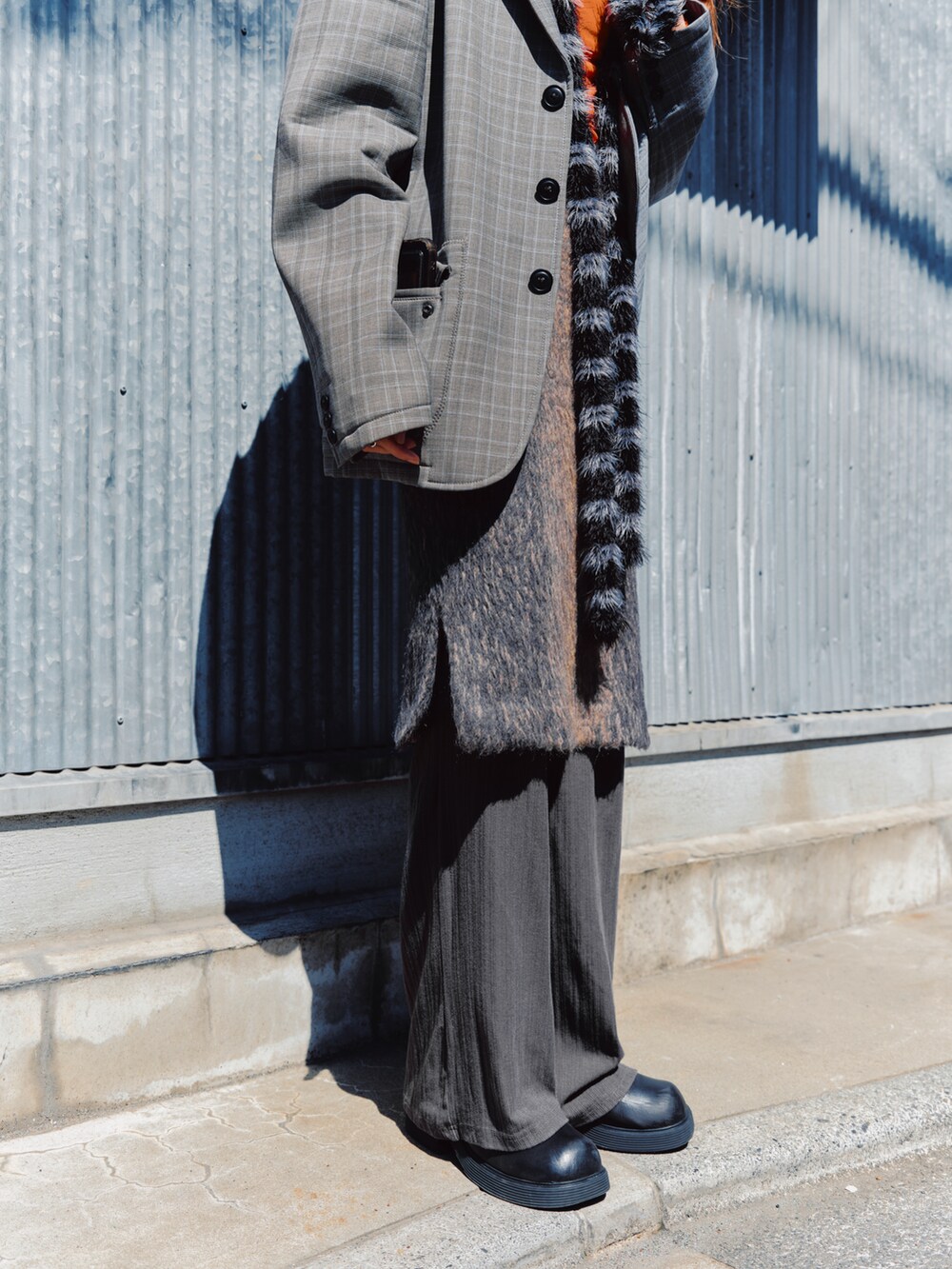 オレンジ系のTシャツ/カットソー、グレー系のテーラードジャケット、ブラウン系のスカートを着用したレディースの春コーディネートの3枚目の写真