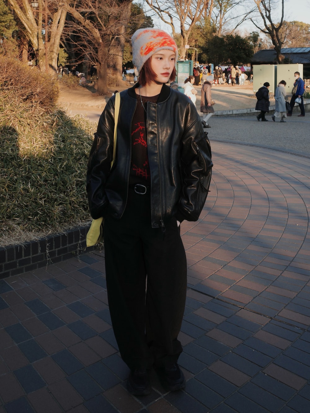 ブラウン系のパンツ、グレー系のニット/セーター、ブラック系のジャケット/アウターを着用したレディースの冬コーディネートの2枚目の写真