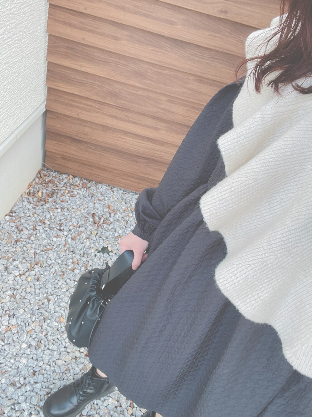 ブラック系のワンピース、ブラック系のトートバッグ、ブラック系のブーツを着用したレディースの春コーディネートの2枚目の写真