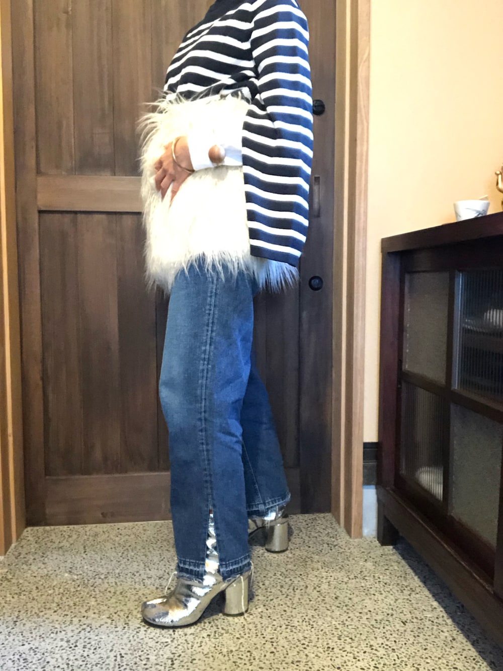 ホワイト系のボディバッグ/ウエストポーチ、ブルー系のデニムパンツ、その他のニット/セーターを着用したレディースの秋コーディネートの2枚目の写真