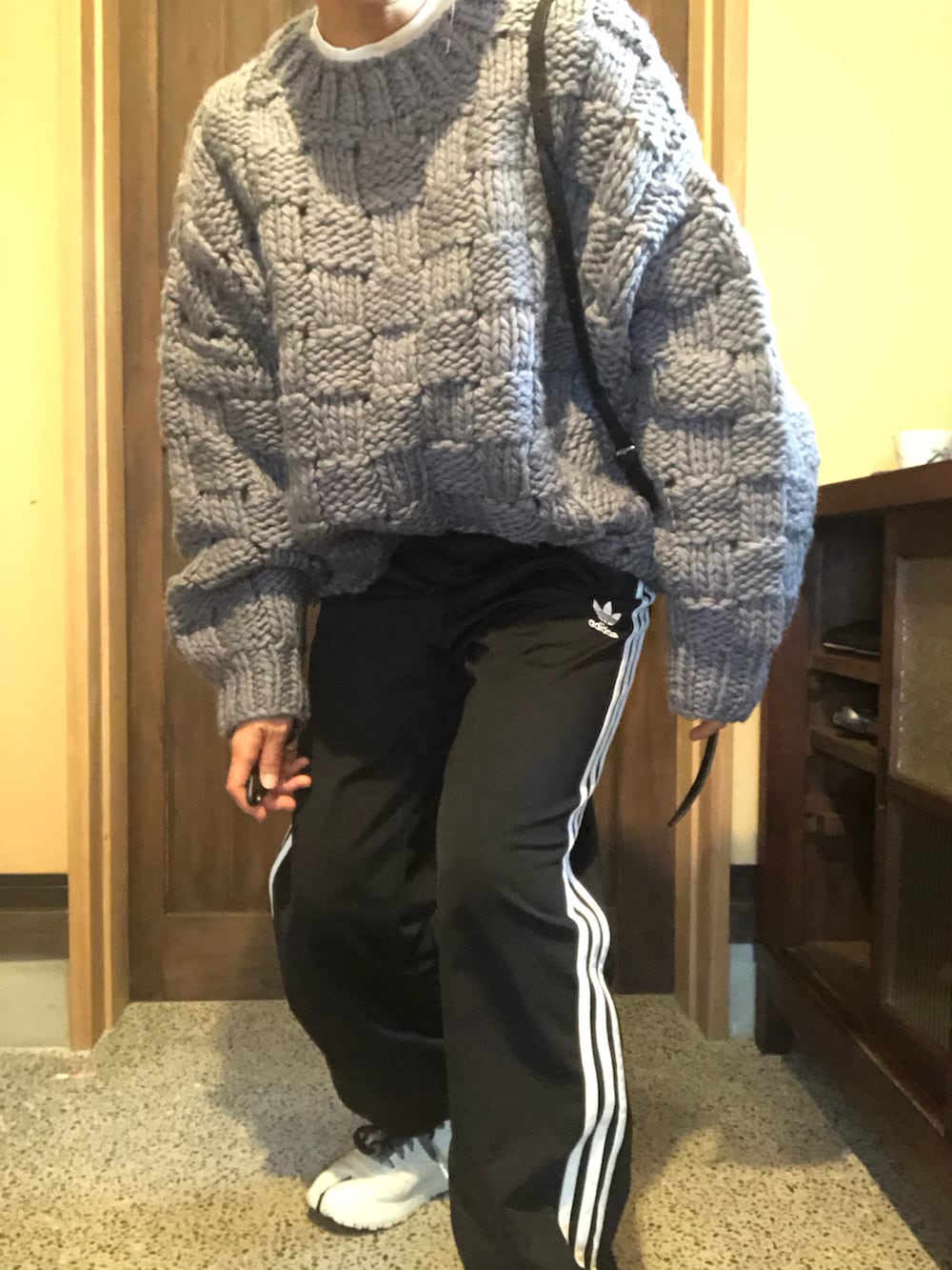 グレー系のニット/セーター、ブラック系のその他パンツ、ホワイト系のスニーカーを着用したレディースの冬コーディネートの3枚目の写真