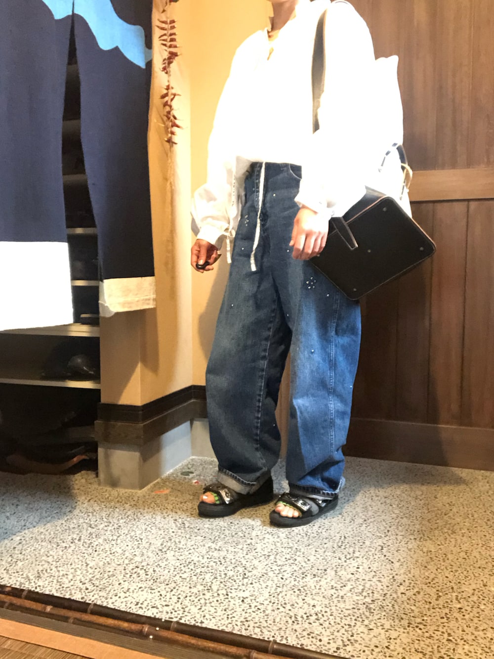 ブラック系のサンダル、ブルー系のデニムパンツ、その他のショルダーバッグを着用したレディースの春コーディネートの2枚目の写真