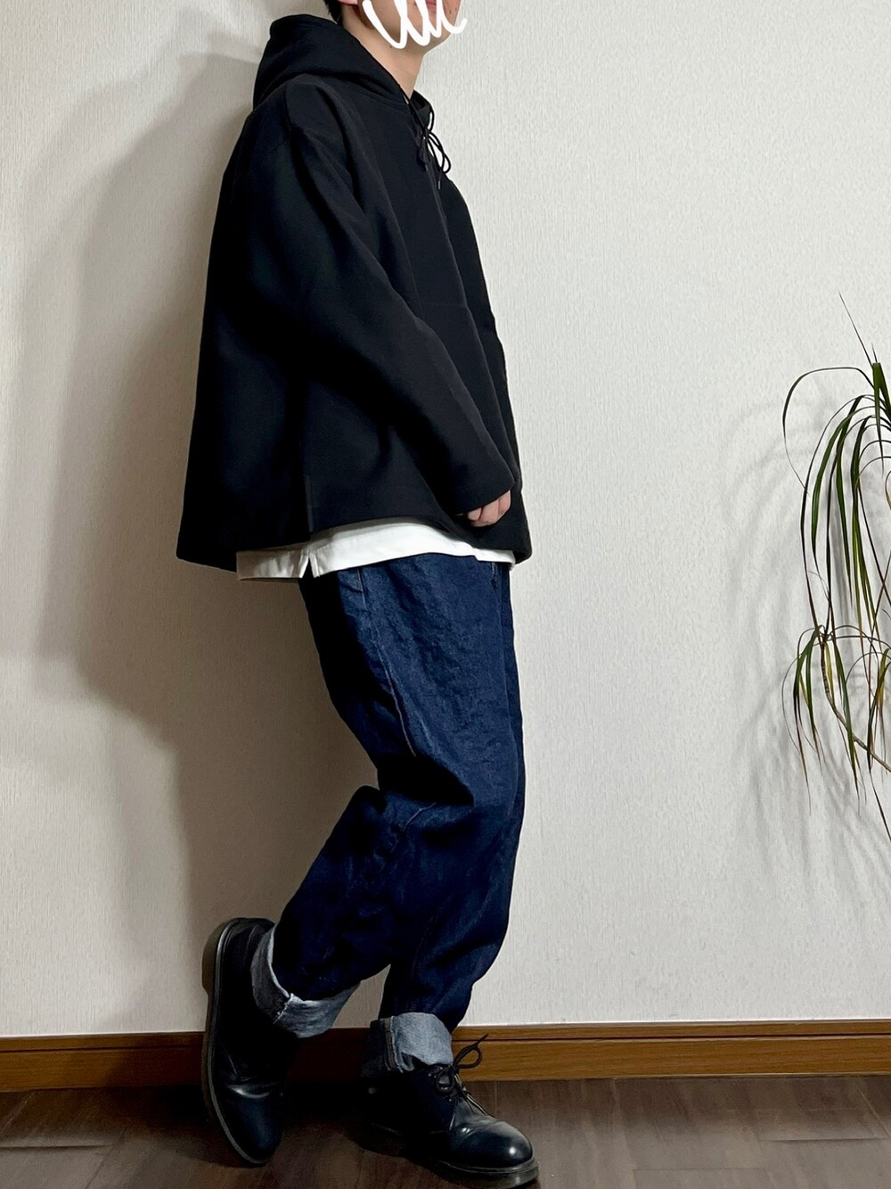 ブラック系のパーカー、ブルー系のデニムパンツ、ホワイト系のスニーカーを着用したメンズの冬コーディネートの3枚目の写真