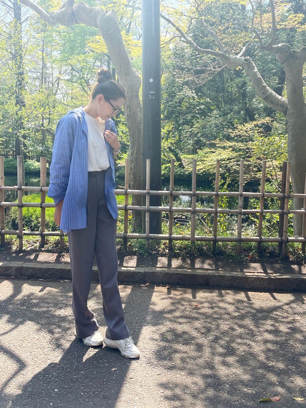 ブルー系のシャツ/ブラウス、グレー系のその他パンツ、シルバー系のバングル/リストバンドを着用したレディースの春コーディネートの2枚目の写真