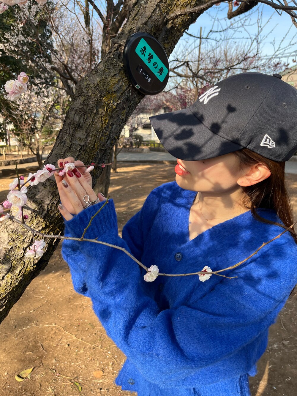 ブルー系のカーディガン/ボレロ、ブラック系のデニムパンツ、ブルー系のキャップを着用したレディースの冬コーディネートの2枚目の写真