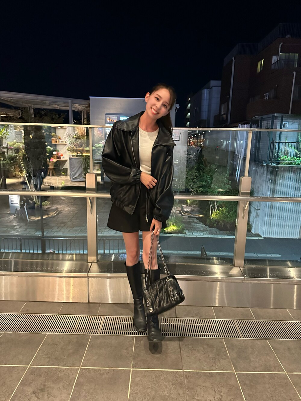 ブラック系のライダースジャケット、ブラック系のブーツ、ブラック系のパンツを着用したレディースの秋コーディネートの2枚目の写真