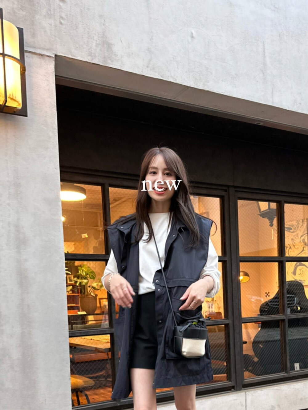 ブルー系のベスト、ホワイト系のTシャツ/カットソー、ブラック系のその他パンツを着用したレディースの春コーディネートの2枚目の写真