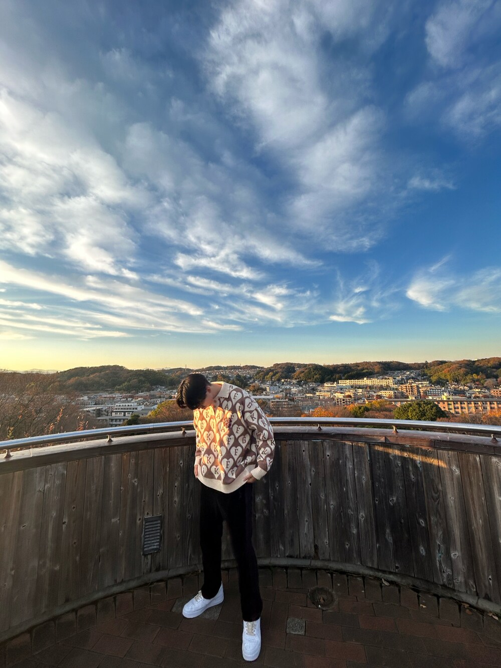 ブラウン系のニット/セーター、ブラック系のパンツ、ホワイト系のスニーカーを着用したメンズの冬コーディネートの2枚目の写真