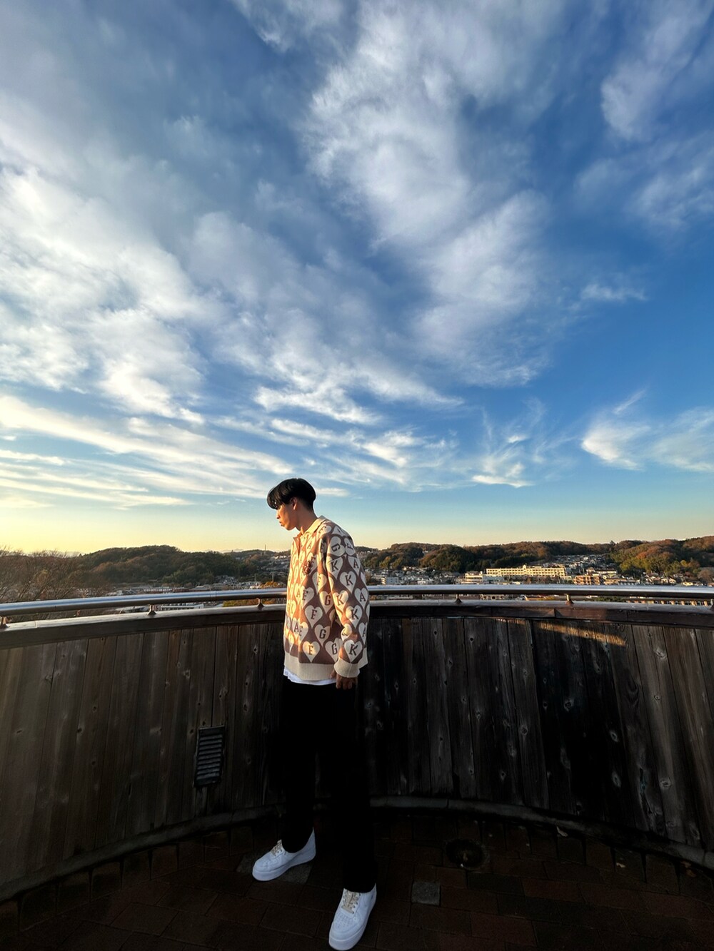 ブラウン系のニット/セーター、ブラック系のパンツ、ホワイト系のスニーカーを着用したメンズの冬コーディネートの3枚目の写真