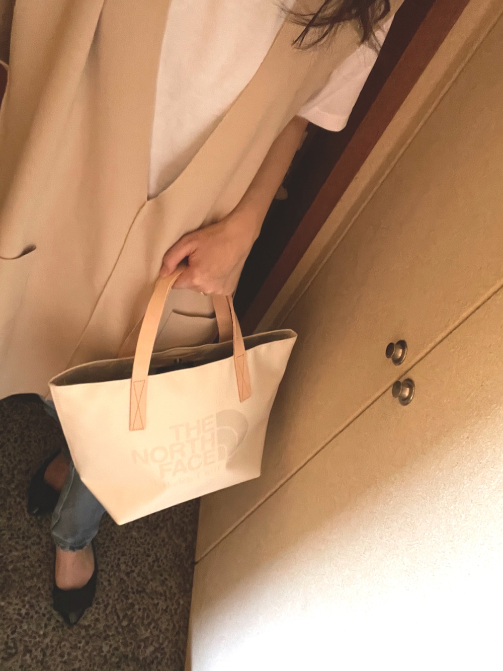 ベージュ系のベスト、ホワイト系のTシャツ/カットソー、ブルー系のデニムパンツを着用したレディースの秋コーディネートの2枚目の写真