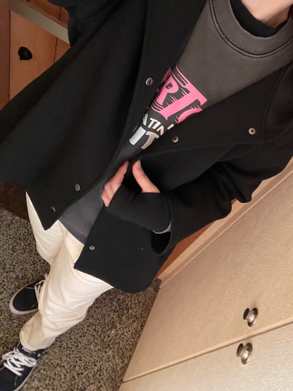 ブラック系のスウェット、ブラック系のTシャツ/カットソー、ホワイト系のデニムパンツを着用したレディースの春コーディネートの2枚目の写真