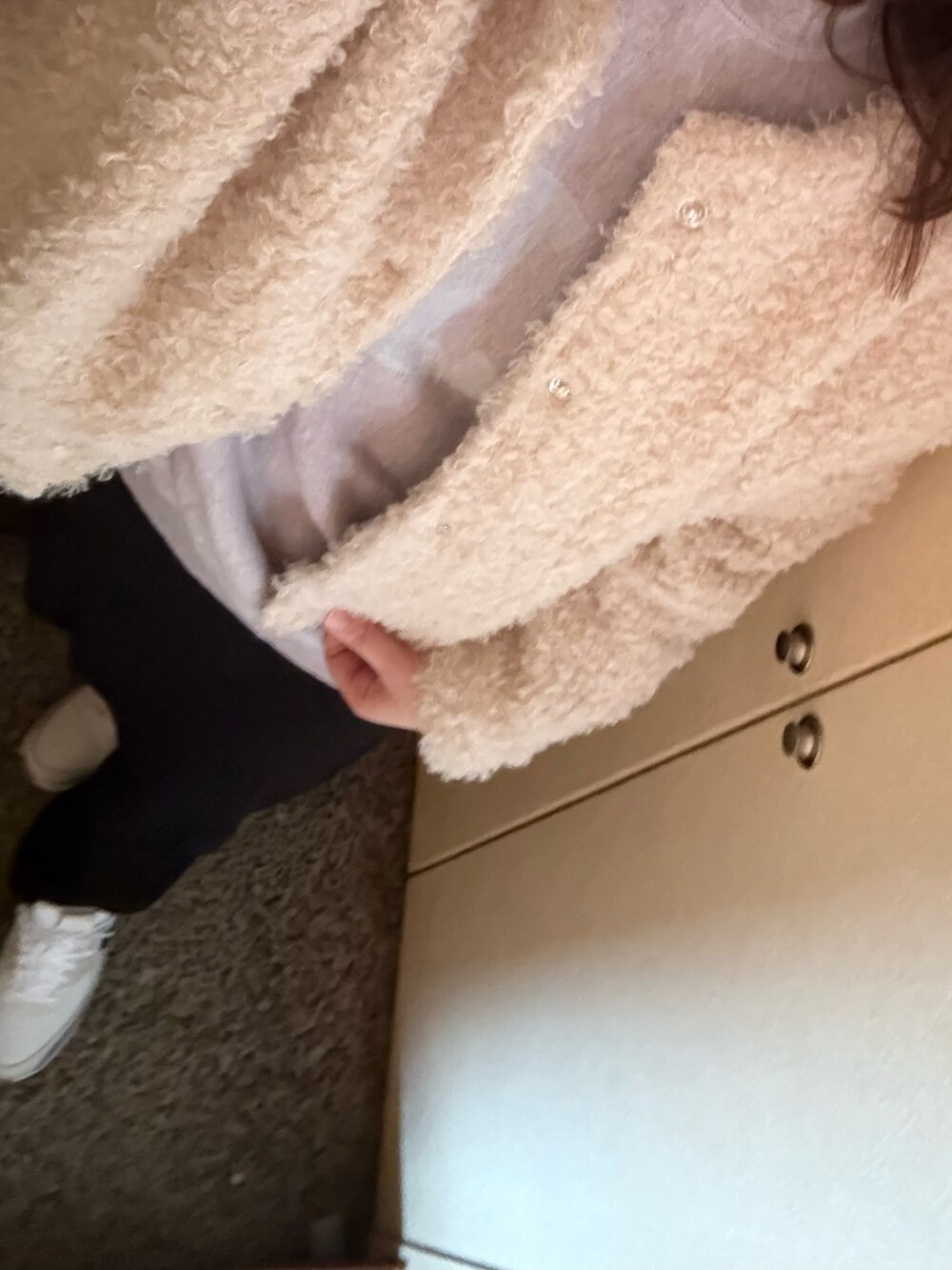 ピンク系のスウェット、ブラック系のスカート、ホワイト系のスニーカーを着用したレディースの冬コーディネートの2枚目の写真