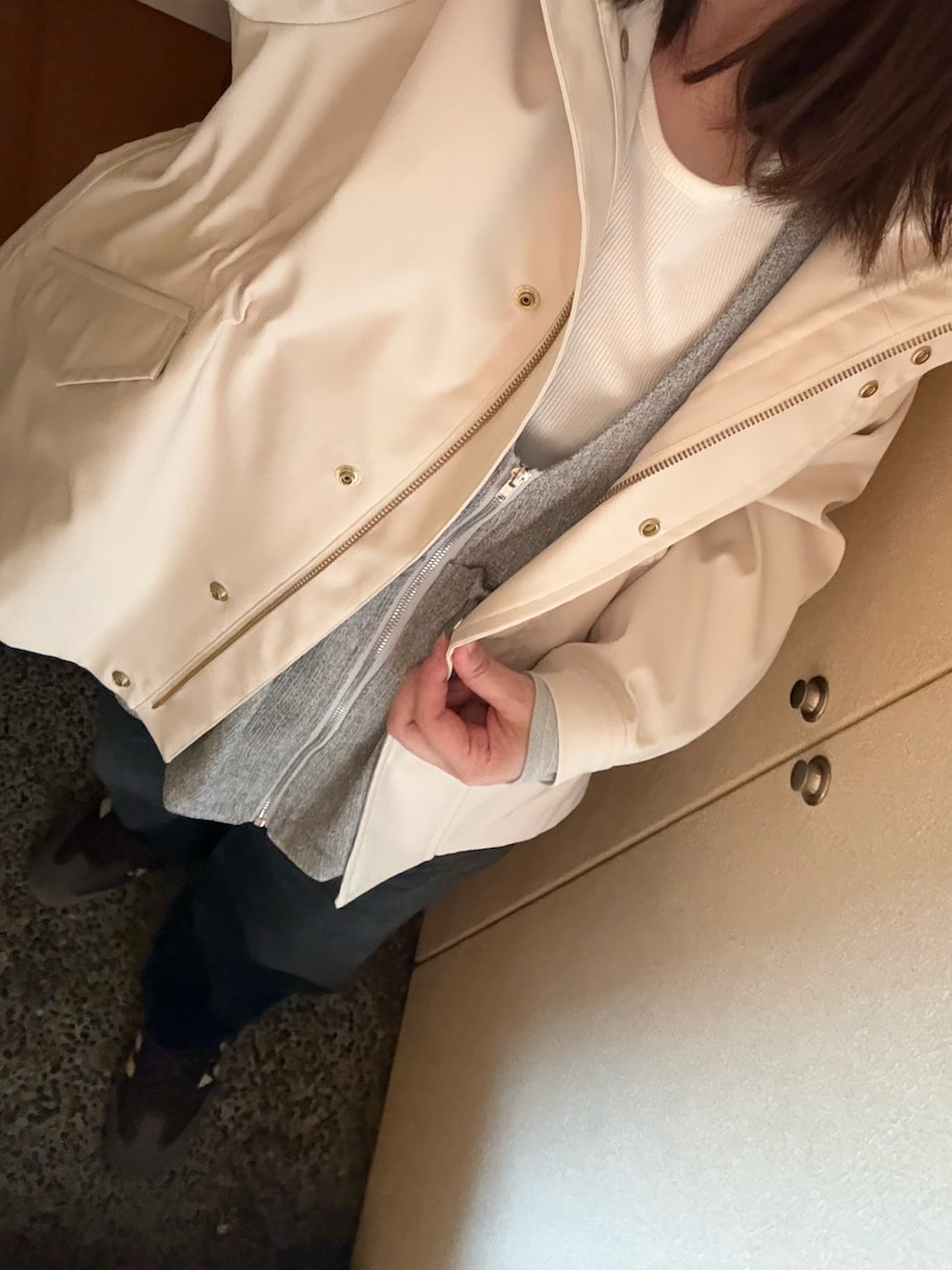 ホワイト系のTシャツ/カットソー、グレー系のベスト、ブラック系のデニムパンツを着用したレディースの春コーディネートの2枚目の写真