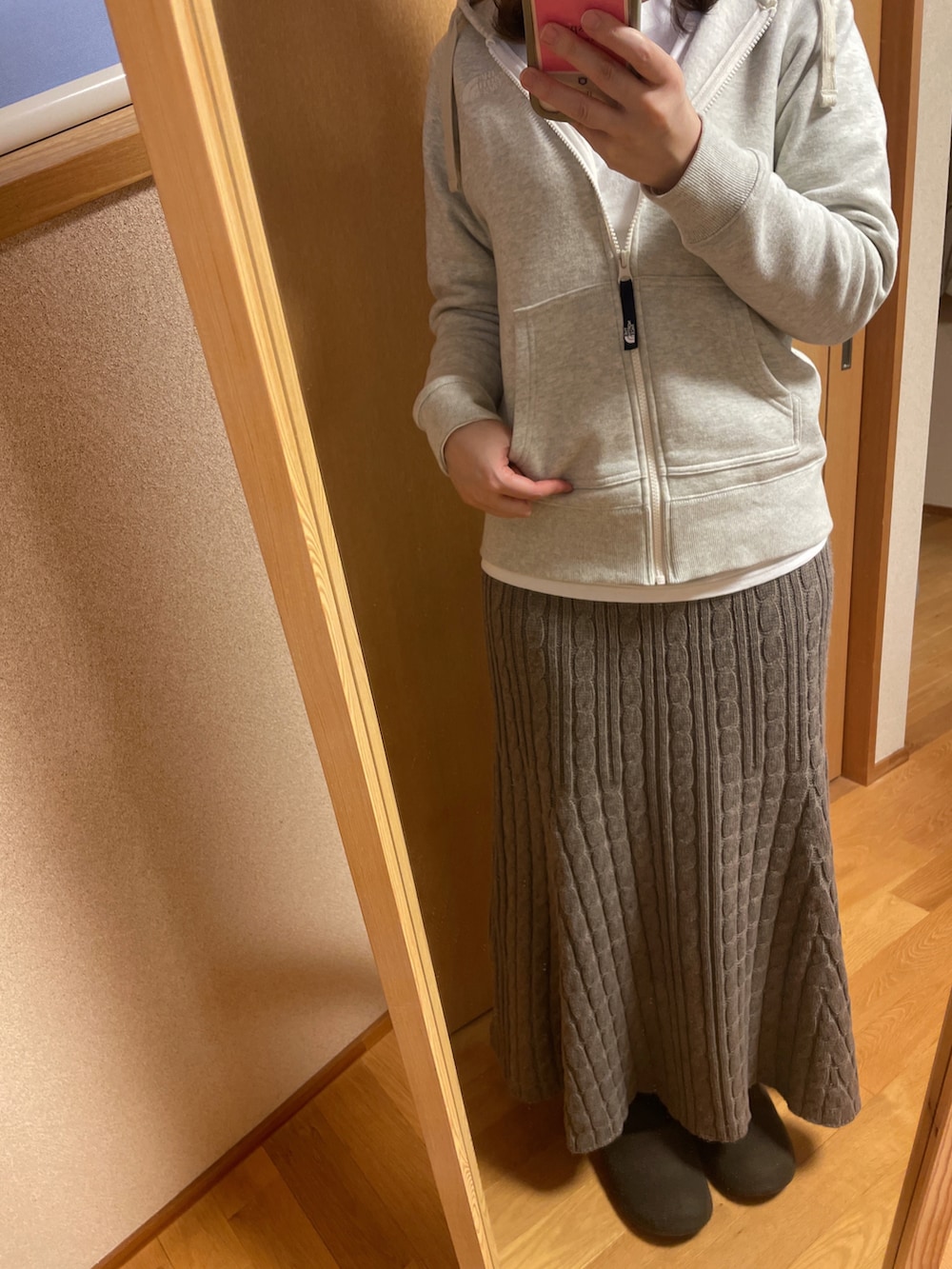 ホワイト系のパーカーを着用したレディースの冬コーディネートの2枚目の写真