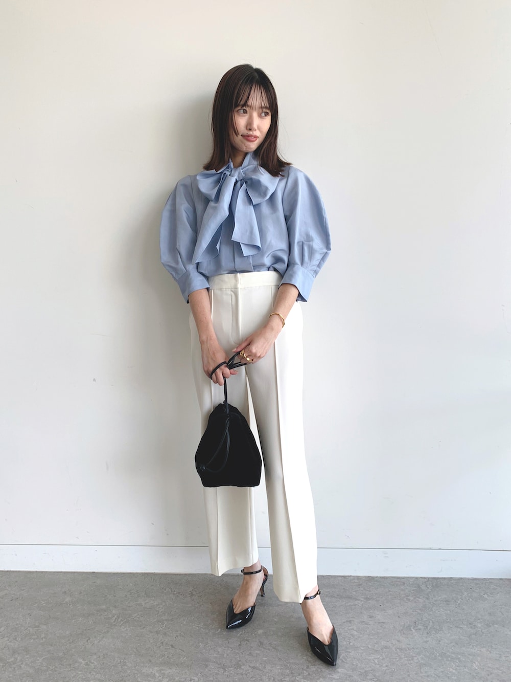 ブルー系のシャツ/ブラウス、ホワイト系のスラックスを着用したレディースの夏コーディネートの2枚目の写真