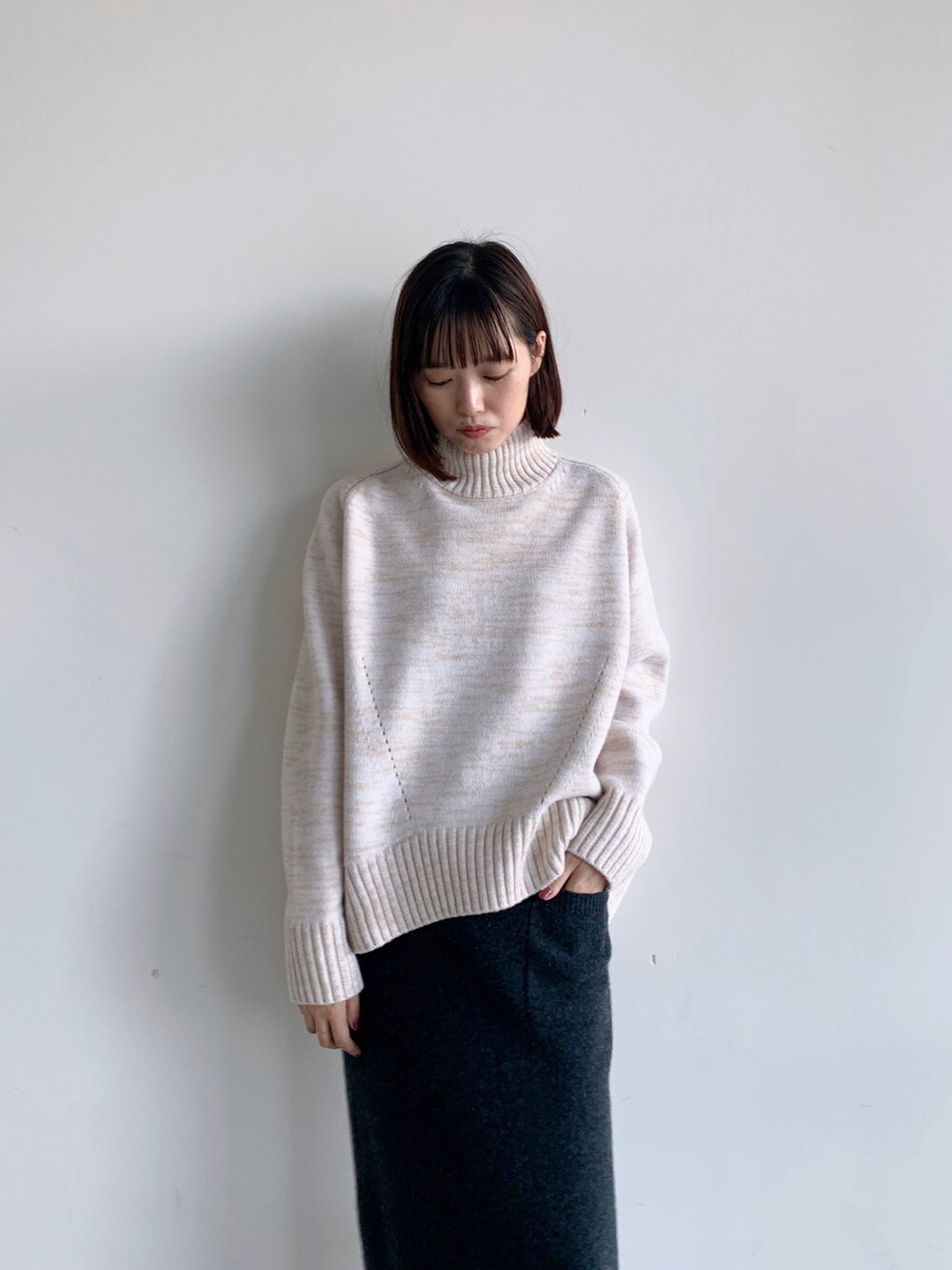 ブルー系のノーカラーコート、グレー系のスカートを着用したレディースの秋コーディネートの4枚目の写真