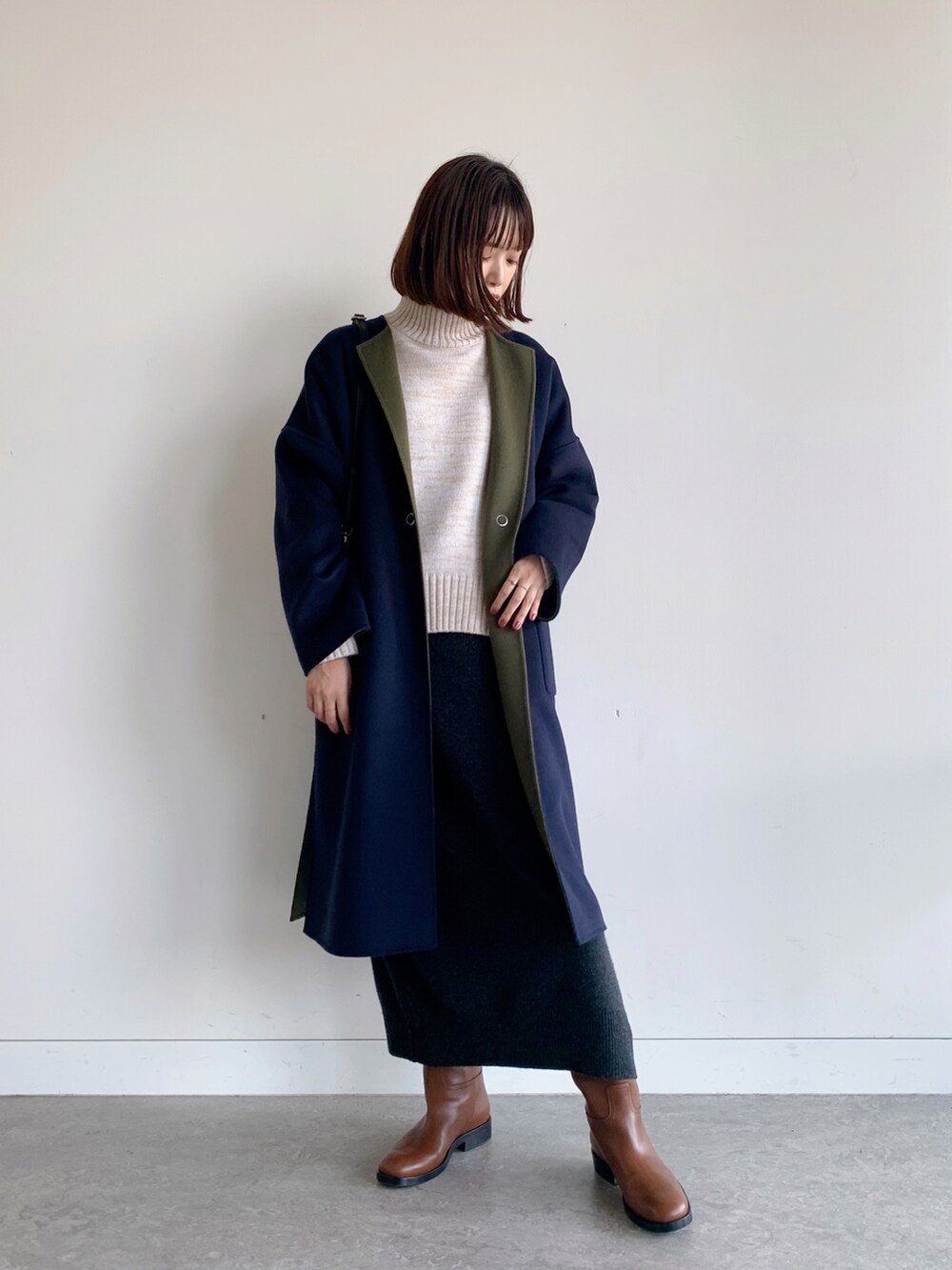 ブルー系のノーカラーコート、グレー系のスカートを着用したレディースの秋コーディネートの3枚目の写真