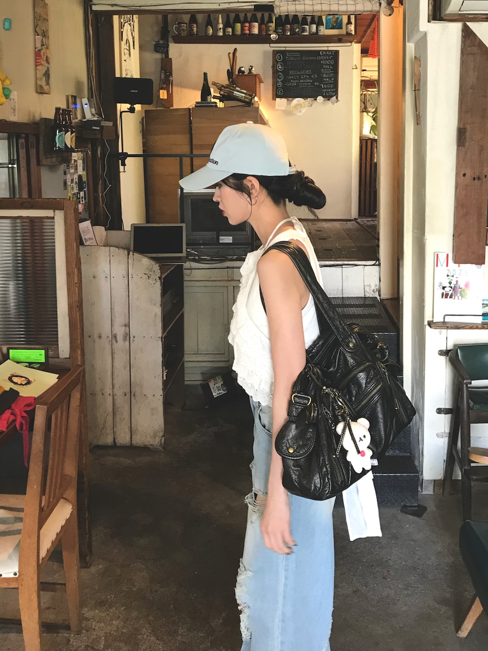 ブルー系のデニムパンツ、ブルー系のキャップを着用したレディースの夏コーディネートの2枚目の写真